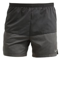 Shorts de sport pour homme bicolores noir et gris foncé, avec une ceinture élastique et un petit logo réfléchissant Nike sur la partie inférieure gauche de la jambe.