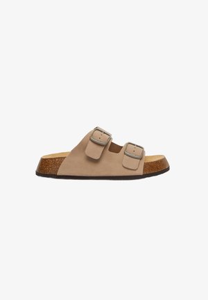 Sandales à glissière en daim beige avec deux boucles argentées ajustables, semelle en liège moulée et semelle en caoutchouc texturé marron.