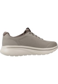 Zapatilla deportiva de malla gris con suela acolchada, puntera redondeada y cordones planos. Presenta una parte superior texturizada y un diseño ligero y flexible.