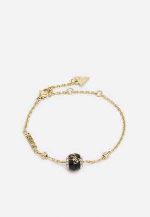 Bracelet en chaîne dorée avec une perle noire centrale rehaussée de petits cristaux et d'un logo, doté d'un fermoir sécurisé et d'une longueur ajustable.