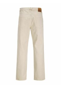 Béžové rovné džínsy s dvěma zadními kapsami a hnědým koženým logem značky na pásku, zobrazené zezadu.