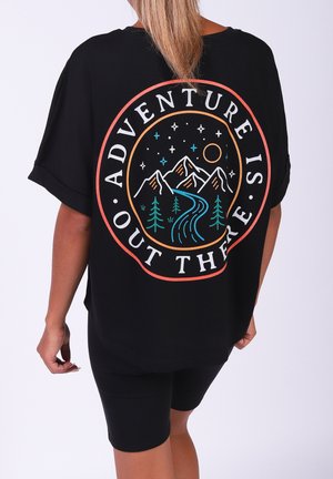 Zwarte oversized t-shirt met een grafisch ontwerp van bergen, bomen en de tekst "AVONTUUR IS DAAAR BUITEN" in levendige kleuren.
