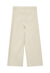 Pantaloni a gamba larga in tessuto beige chiaro, caratterizzati da due tasche posteriori e una texture liscia. L'orlo cade sotto la caviglia con una rifinitura pulita.