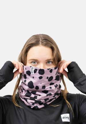 Light purple neck gaiter with black scattered spots, made of soft fabric, featuring a logo tag. Worn by a person with long hair.