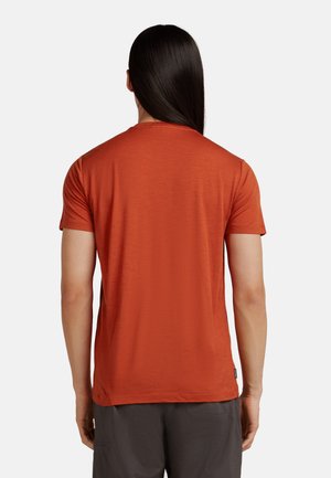 Korte mouw, ronde hals t-shirt in verbrand oranje, gemaakt van textuurstof. Heeft een rechte zoom en minimaal merk op de onderkant.