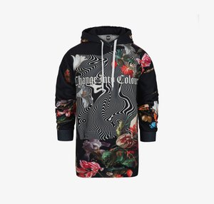 Huppari mustana kukkakuviolla ja pyörivillä viivoilla. Edessä on graafinen teksti "Muuta väriä." Kangas on puuvillasekoitetta.