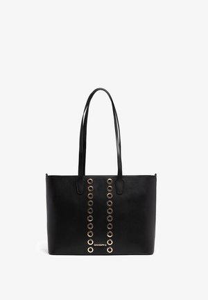 Black tote bag featuring gold-tone grommets down the center, made of smooth synthetic material, with two long handles and a rectangular shape.