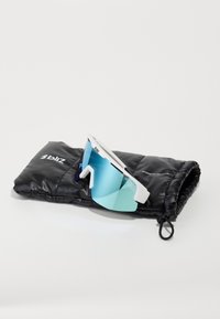 Lunettes de soleil avec une monture blanche et des verres dégradés bleus, reposant sur un étui rembourré noir avec branding, mettant en avant un design épuré et des fonctionnalités pratiques.