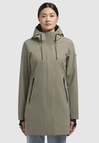 Giacca a vento resistente all'acqua di colore verde oliva, con una vestibilità slim, maniche lunghe, due tasche laterali con zip e cordini regolabili.