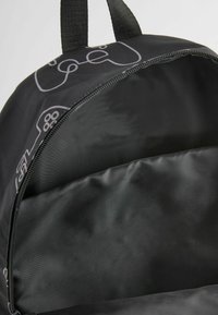 Schwarzer Rucksack mit runder Form, der ein grafisches Design eines Gaming-Controllers zeigt. Das Innere ist gefüttert und glatt.