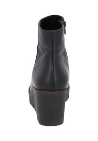Botte de cheville en cuir noir avec bout rond, fermeture éclair sur le côté, semelle brune contrastante et design à talon épais. Texture lisse avec des coutures discrètes.