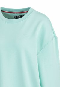 Muntgroene sweatshirt van zacht materiaal. Heeft een ronde hals en een drop shoulder ontwerp. Subtiele, reliëf logo nabij de halslijn.