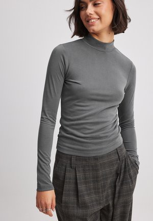 Sivý dlhý rukáv turtleneck top z jemnej tkaniny s priliehavým strihom, ktorý obsahuje jemné zberanie, skombinovaný s kockovanými nohavicami s vysokým pásom.