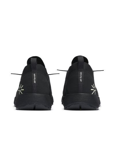 Black sneakers with a textured finish, featuring a padded collar, flat laces, and a reflective logo on the heel. Lightweight, flexible sole.