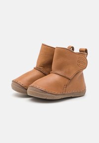 Botas de tobillo de cuero marrón con punteras redondeadas, detalles de costura y una lengüeta en la parte posterior. Suela blanda para mayor comodidad y flexibilidad.