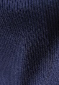 Tissu en tricot ribbed bleu marine avec une surface texturée, présentant des lignes verticales et une sensation douce et élastique. Convient pour l'habillement ou la tapisserie.