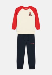 Svet outfit i bomuld med en cremefarvet top med røde raglanærmer og grafik, parret med navy joggers. Inkluderer elastisk talje.