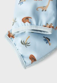 Hellblauem Stoff mit verschiedenen Mustern von Dinosauriern und Palmen. Weiche Fleece-Innenseite und glatte Außenseite mit genähten Kanten.