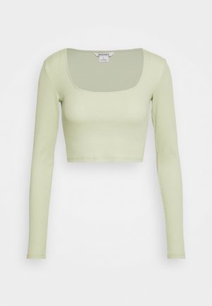 Haut court à manches longues côtelé vert clair avec un décolleté carré, une silhouette ajustée et une étiquette de marque à l'intérieur du col.