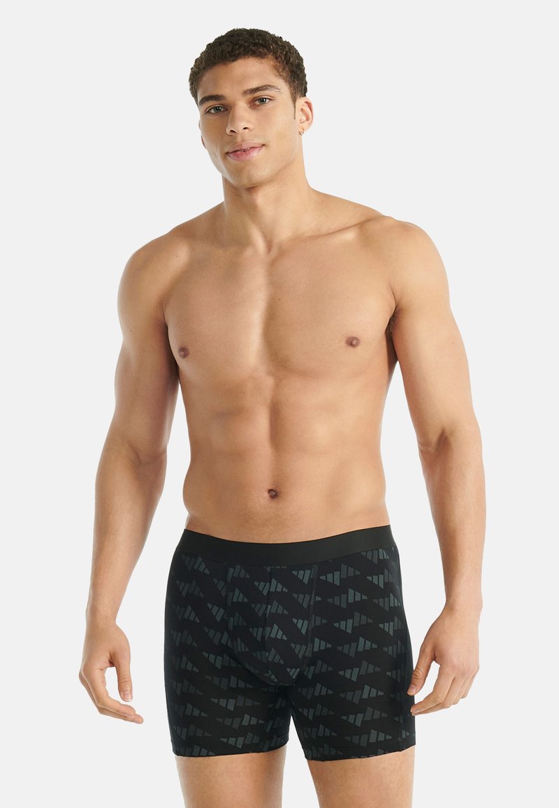 Černé boxerky s geometrickým vzorem. Vyrobené z měkkého materiálu, s hladkým pasem a přiléhavým střihem.
