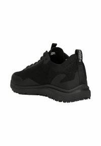 Black athletic shoe featuring a mesh upper, textured sides, padded collar, and rubber sole with grip patterns. Minimalistic design.
