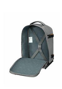 Grijze rugzak met een gestructureerd ontwerp, voorzien van verstelbare schouderbanden, een interieur met een gestreepte voering en een veilige voorflap.