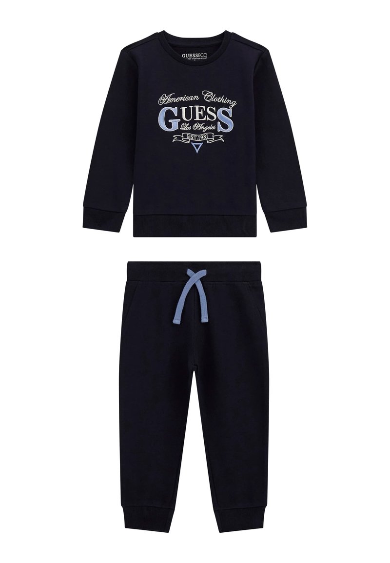 Marineblaues Zweiteiler-Set bestehend aus einem langärmligen Sweatshirt mit Logo und passenden Sweatpants mit einer hellblauen Kordel. Aus Baumwollmaterial.