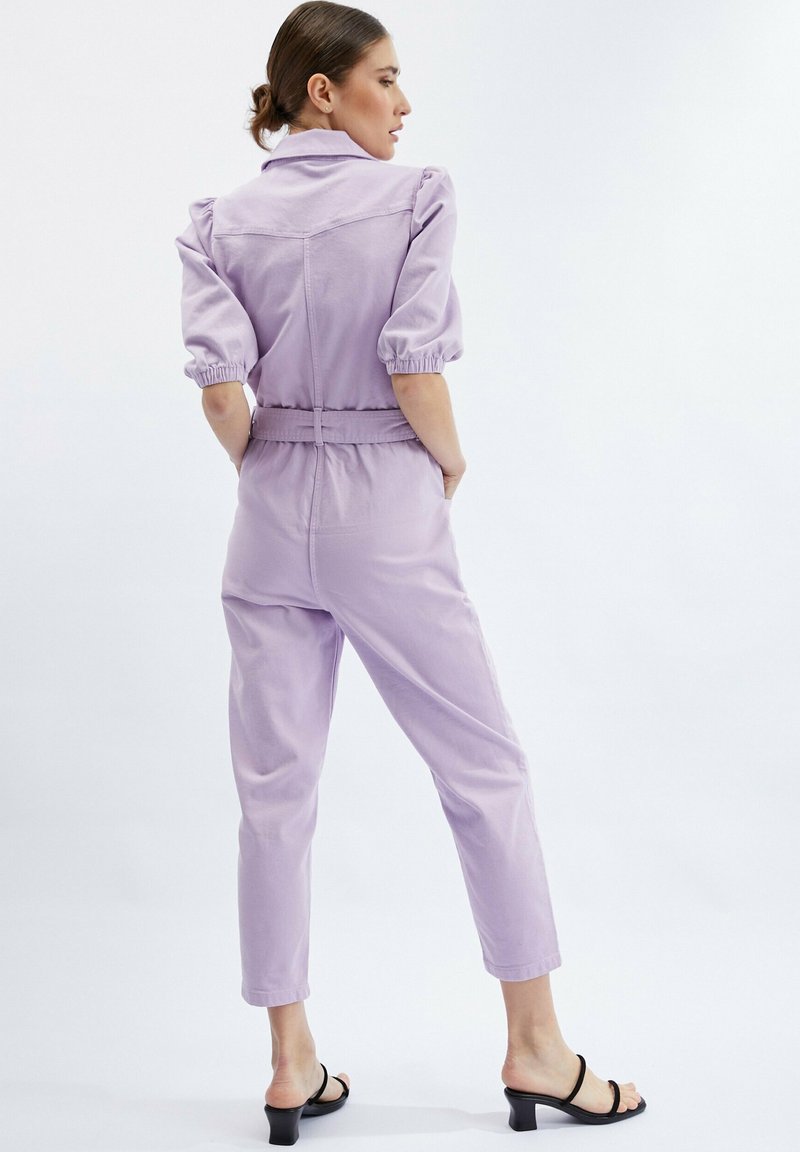 Lavendel jumpsuit met korte pofmouwen, een aansluitende taille en taps toelopende benen. Heeft een kraag en elastische manchetten. Minimalistisch ontwerp.