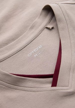 T-shirt beige con tessuto texturizzato, caratterizzato da un collo a V e un accento bordeaux sul colletto interno. L'etichetta recita "ombre M 14."