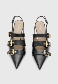 Sorte skinn slingback hæler med spiss tå, tre dekorative spennebånd, gullfarget detaljer og en glatt innersåle.