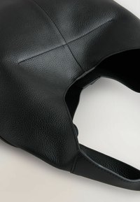 Borsa a spalla in pelle nera con superficie testurizzata, forma curvata e design minimalista, arricchita da dettagli cuciti e apertura superiore.