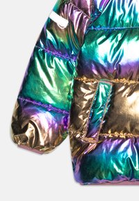 Iridescent pufferjacka ärm i nyanser av lila, blått och guld. Den har en texturerad, glänsande yta med synliga sömmar och ficka.