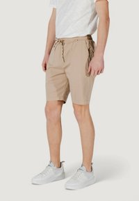 Pantaloni corti beige realizzati in tessuto leggero, con cintura elastica con cordino, tasche laterali e vestibilità comoda.
