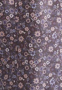 Donkere bloemenstof met kleine witte, blauwe en taupe bloemen op een diep groene achtergrond met een gestructureerde afwerking.