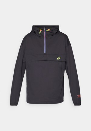 Veste légère noire avec capuche, fermeture éclair mi-longue à l'avant, zip bleu en accent, logo vert fluo et détail de bande rouge sur la manche.