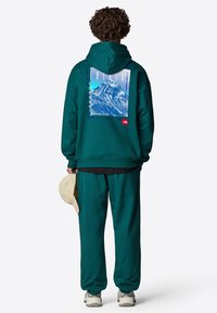 Sudadera con capucha y pantalones de chándal en color verde azulado, hechos de una tela suave, con un gráfico de montaña en la parte posterior que incluye el texto "EVEREST". Lleva un acento de logo.