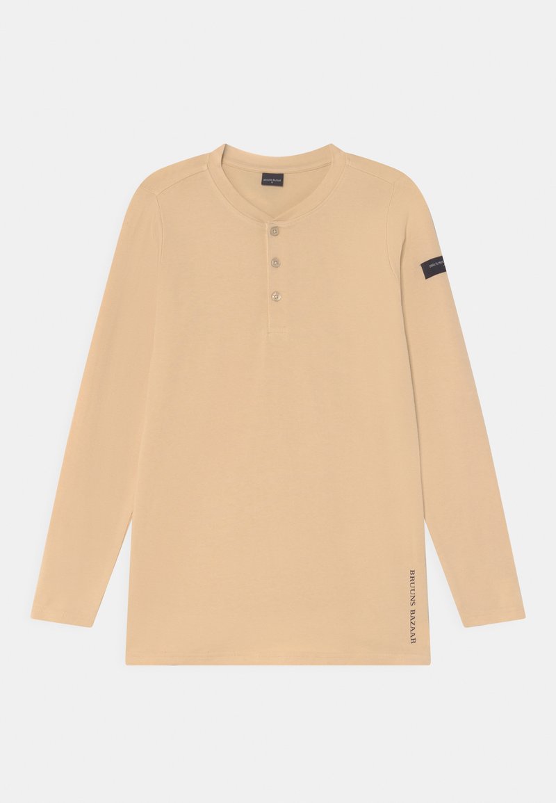 Camisa henley de manga longa em tom beige, feita de um tecido suave, com três botões na frente, um decote redondo e um logótipo na manga esquerda.