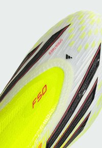 Ποδοσφαιρικό παπούτσι F50 με κίτρινο και άσπρο σχέδιο, μαύρες λεπτομέρειες, υφή στην επιφάνεια και έντονα διακριτικά της μάρκας.