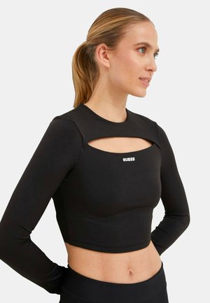 Top cropped nero a maniche lunghe con un design con scollatura sul davanti, caratterizzato da un logo bianco. Realizzato in un tessuto liscio e aderente.
