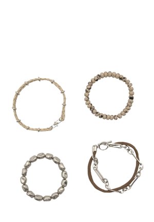 Vier Armbänder: eine gewebte beige Schnur, eine glatte beige Perle, ein metallischer ovaler Glied und eine braune Schnur mit einem Metallverschluss. Verschiedene Texturen und Farben.