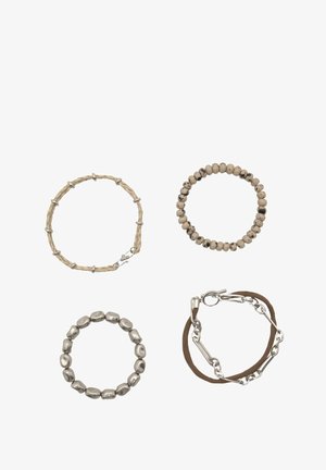 Vier Armbänder: eine gewebte beige Schnur, eine glatte beige Perle, ein metallischer ovaler Glied und eine braune Schnur mit einem Metallverschluss. Verschiedene Texturen und Farben.