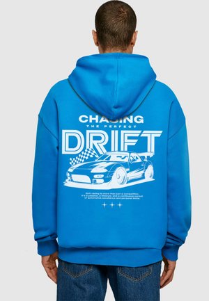 Blue hoodie in a relaxed fit with a large white graphic of a car and text on the back. Features ribbed cuffs and a drawstring hood.