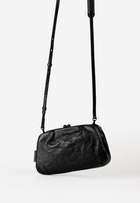 Borsa a tracolla nera in pelle con forma arrotondata, superficie testurizzata e dettaglio di chiusura distintivo. Tracolla regolabile per un uso versatile.