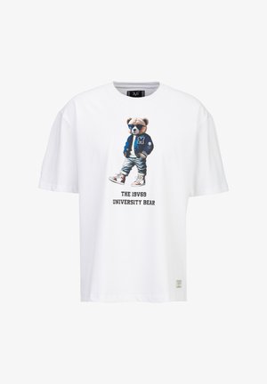 Wit T-shirt met een afbeelding van een beer die een zonnebril draagt, een blauw varsity jack, spijkerbroek en sneakers, met de tekst "THE 19V69 UNIVERSITY BEAR."