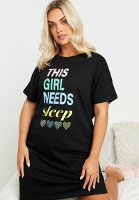 Svart kortärmad nattskjorta med färgglad text: "DEN HÄR FILEN BEHÖVER SÖMN" med mönstrade hjärtan i olika färger nedanför.