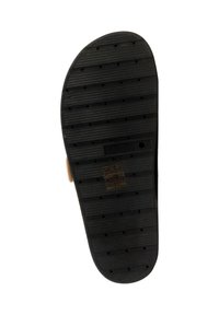 Semelle en caoutchouc noir d'une chaussure avec des rainures horizontales, de petits trous circulaires et la taille 39 visible sur un fond blanc.