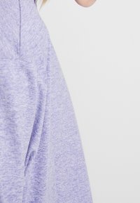 Felpa over-size in tessuto strutturato di colore viola con spalle scese, design minimal e cuciture sottili, che mette in risalto una vestibilità rilassata.