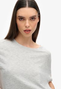 Grijze t-shirt met korte mouwen, gemaakt van een zachte stof en een ontspannen pasvorm, met een ronde halslijn en minimale stiksels.