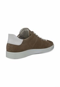 Bruna mockasn sneakers med vita accenter, med rund tå, snörning fram och en texturerad innersula. Platt gummisula.