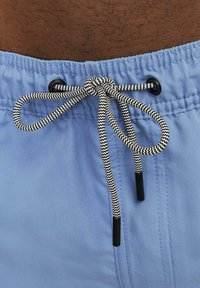 Pantalones cortos de color azul claro con un cordón de patrón en blanco y negro con puntas negras, cinturilla elástica y textura suave.